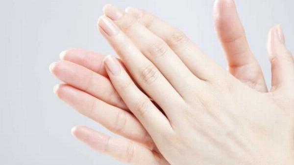 Cận cảnh ngón tay được massage bằng dầu tự nhiên, là bí quyết dưỡng móng tay dài nhanh